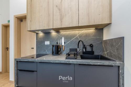 a kitchen with a sink and a counter top at House CAPRI with heated pool and sea view in Klimno