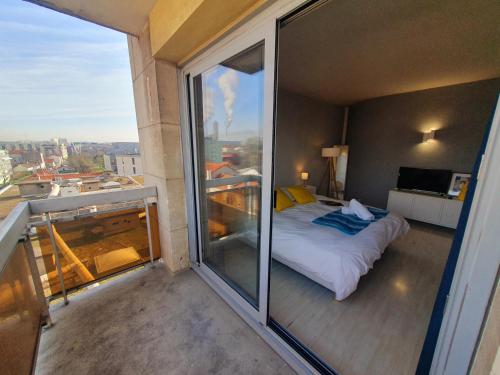 a bedroom with a bed on a balcony at View on Paris in Ivry-sur-Seine