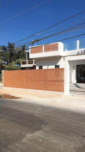 a building with a red brick wall next to a street at TerraCotta Beachfront Villa Phan Thiet in Phan Thiet