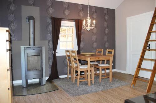 a dining room with a table and a wood stove at Blockhouse Nicks Lodge in Hatten