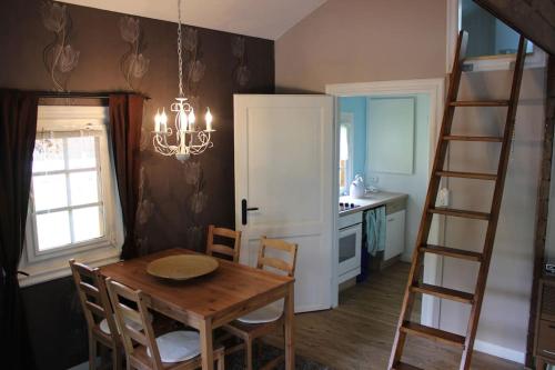 a dining room with a table and a ladder at Blockhouse Nicks Lodge in Hatten