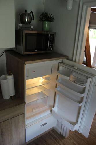 an open refrigerator with a microwave in a kitchen at Blockhouse Nicks Lodge in Hatten