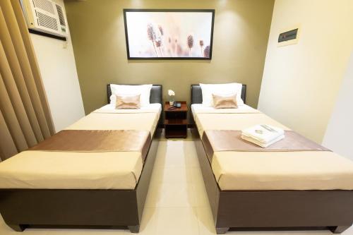 two beds in a small room with at Soleil Suites Cebu in Cebu City