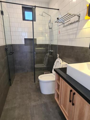 a bathroom with a toilet and a sink and a shower at TerraCotta Beachfront Villa Phan Thiet in Phan Thiet