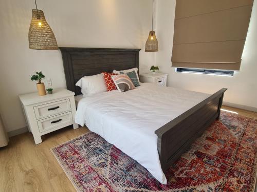 a bedroom with a large bed and a rug at TerraCotta Beachfront Villa Phan Thiet in Phan Thiet