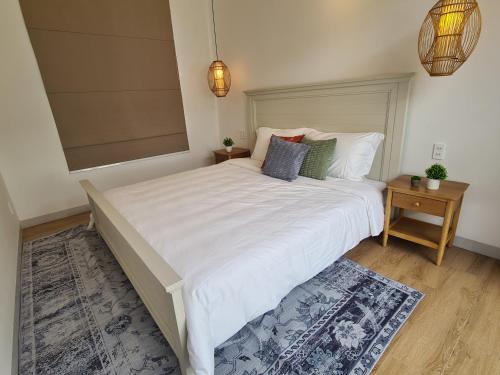 a bedroom with a large bed with white sheets and pillows at TerraCotta Beachfront Villa Phan Thiet in Phan Thiet
