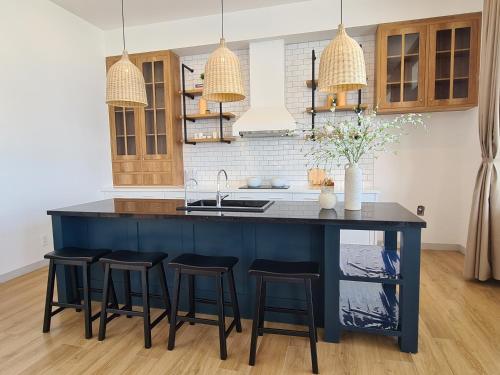 a kitchen with a blue island with bar stools at TerraCotta Beachfront Villa Phan Thiet in Phan Thiet