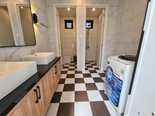 a bathroom with a black and white checkered floor at TerraCotta Beachfront Villa Phan Thiet in Phan Thiet