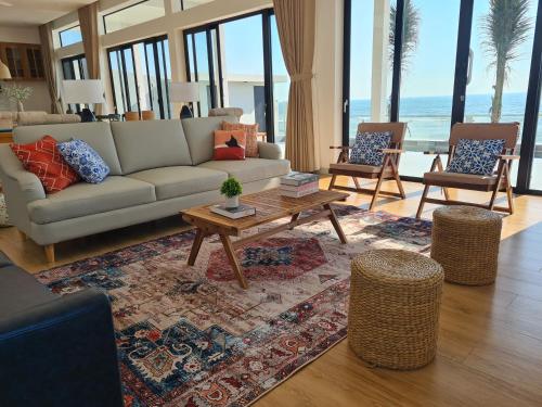 a living room with a couch and a table and chairs at TerraCotta Beachfront Villa Phan Thiet in Phan Thiet