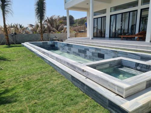 a swimming pool in front of a house at TerraCotta Beachfront Villa Phan Thiet in Phan Thiet