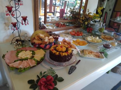 a buffet of food on a table with a cake at Bromélia Sabiá & Cia in Teresópolis