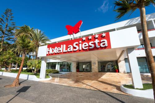 een hotel la casita met een rode vogel bovenop bij Alexandre Hotel La Siesta in Playa de las Americas