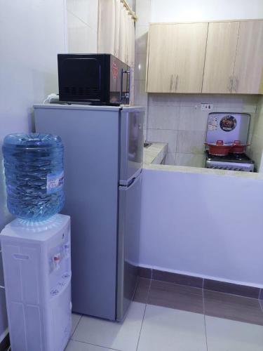a kitchen with a microwave on top of a refrigerator at Roma Stays - Budget Studio in Busia (Opp Shell petrol Station) in Busia