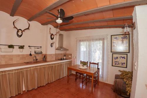 cocina con mesa y ventilador de techo en El Cortijo, en Hellín
