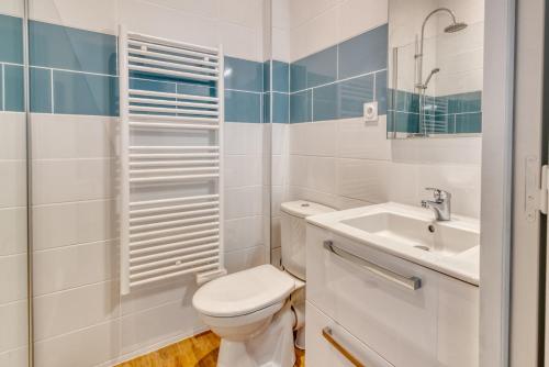 une salle de bain blanche avec des toilettes et un lavabo dans l'établissement Sainte-Catherine by Yumē, à Toulouse