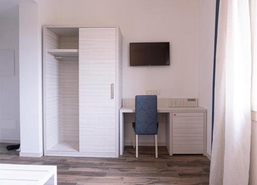 a white room with a desk and a blue chair at Guest House DOLCE LAGUNA 2 in Tessera