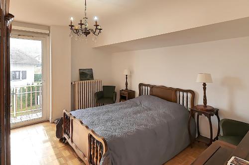 a bedroom with a bed and chairs and a chandelier at Villa P'tite Noisette - charmante maison vue montagne in La Bresse