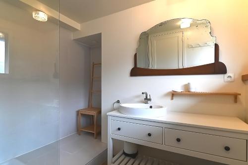 a bathroom with a sink and a mirror at Villa P'tite Noisette - charmante maison vue montagne in La Bresse