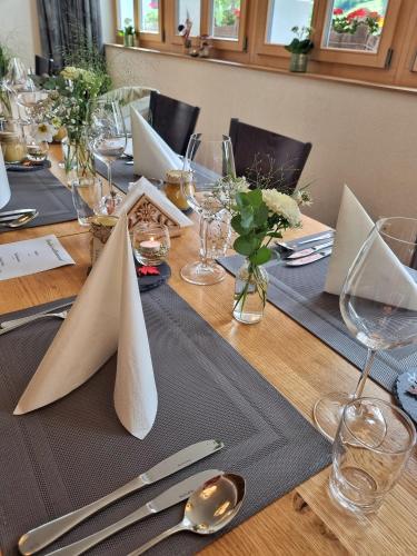 a long wooden table with napkins and silverware on it at Triftblick in Gadmen