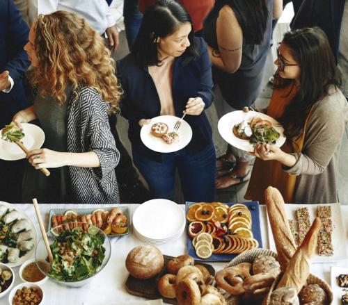 a group of people standing around a table with food at Holiday Inn Chicago Midway Airport S by IHG in Chicago
