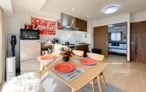a kitchen and dining room with a table with red plates at 安楽途 in Tokyo