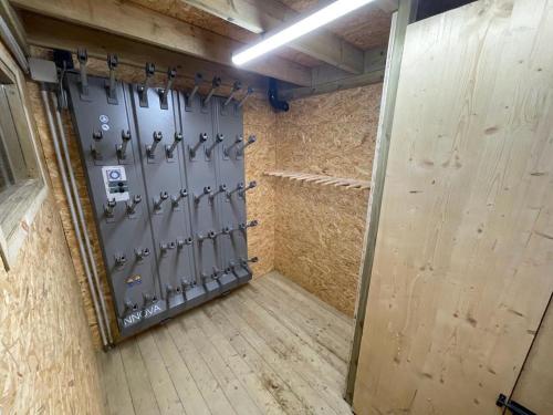 a locker room with a metal door with hockey equipment at Chalet Folie in Peisey-Nancroix