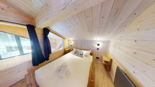a small room with a bed in a tiny house at Chalet Folie in Peisey-Nancroix