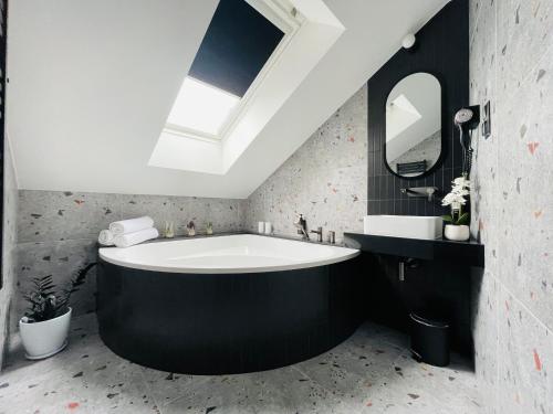 a large bath tub in a bathroom with a skylight at Hotel Millennium in Przasnysz