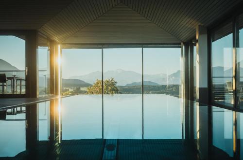 a house with a pool with a view of the mountains at Romantik Spa Hotel Elixhauser Wirt in Elixhausen