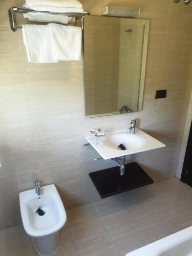 a bathroom with a sink and a toilet and a mirror at Hotel Millan in Negreira