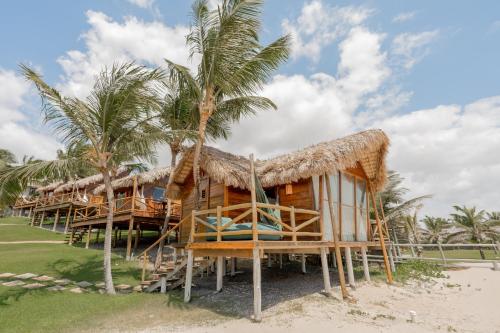 a resort on the beach with palm trees at Villa Mango in Icaraí