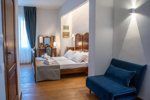 a bedroom with a bed and a blue chair at Residenza degli Speziali in Florence