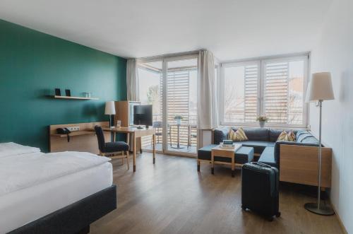 een slaapkamer met een bed en een woonkamer bij Romantik Spa Hotel Elixhauser Wirt in Elixhausen