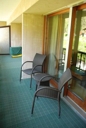 two chairs and a glass table on a porch at Chesa La Furia in Pontresina