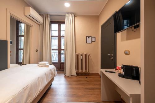 una camera con un grande letto e una televisione di Torino Station Relais a Torino