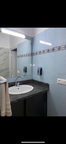 uma casa de banho com um lavatório e um espelho em Appartement à 8 mn de mehdia plage em Kenitra
