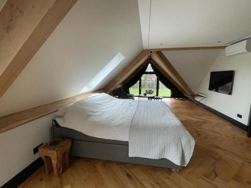 ein Schlafzimmer mit einem großen Bett im Dachgeschoss in der Unterkunft B&B Il Settimo Cielo in Someren