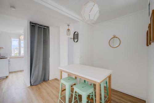 une cuisine avec une table et deux tabourets dans l'établissement Mermoz by Yumē, à Toulouse