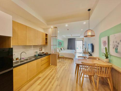 - une cuisine et une salle à manger avec une table et un lit dans l'établissement TMS Beachfront Apartment Quy Nhon Bay, à Quy Nhơn