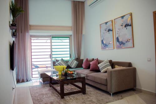 een woonkamer met een bank en een salontafel bij Appartement Élégant in Marrakesh