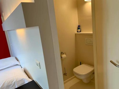 een kleine badkamer met een bed en een toilet bij vakantiewoning het vijverhuis in Zillebeke