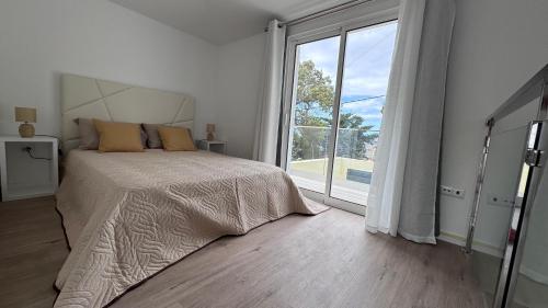 a bedroom with a bed and a large window at VCS House by Madeira Holiday in Funchal