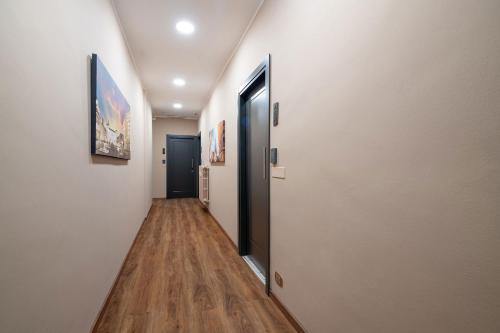 a hallway with a door leading to a hallway with wood floors at Torino Station Relais in Turin