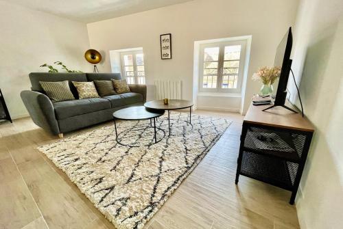un salon avec un canapé et un tapis dans l'établissement Le jardin des Hautes Presles Le Fer à cheval, à Fontainebleau
