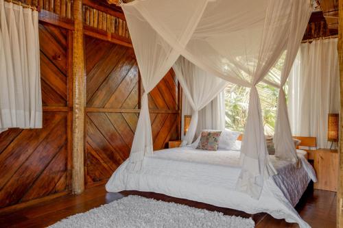a bedroom with a canopy bed with wooden walls at Villa Mango in Icaraí