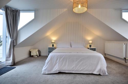 a bedroom with a large white bed in a attic at 5 St Ives in St Ives