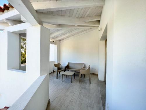 a room with white walls and a table and chairs at La Residenza del Mare in Limpiddu