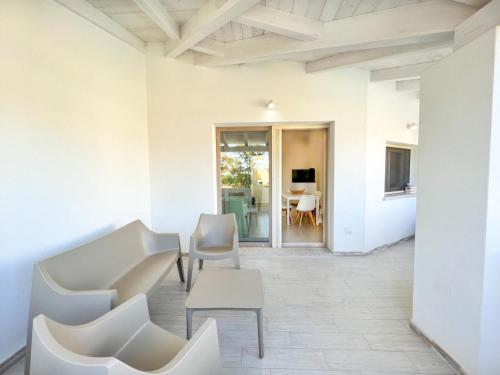a living room with white chairs and a table at La Residenza del Mare in Limpiddu