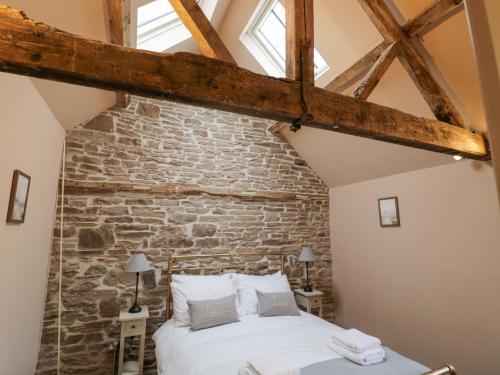 a bedroom with a brick wall and a bed at Meadow Barn in Leominster