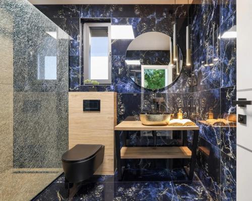 a bathroom with a blue tiled wall at Villa Royal Sands in Privlaka